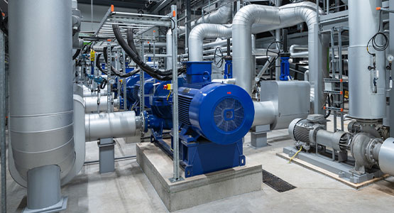 Industrial facility with blue machinery and metal pipes in a modern factory setting.