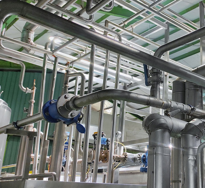 Industrial pipes and valves in a factory setting.