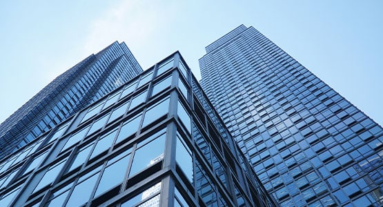 Skyscrapers with glass facades reaching towards a clear blue sky.