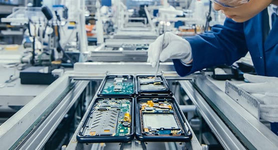 A technician assembling smartphones on a production line.
